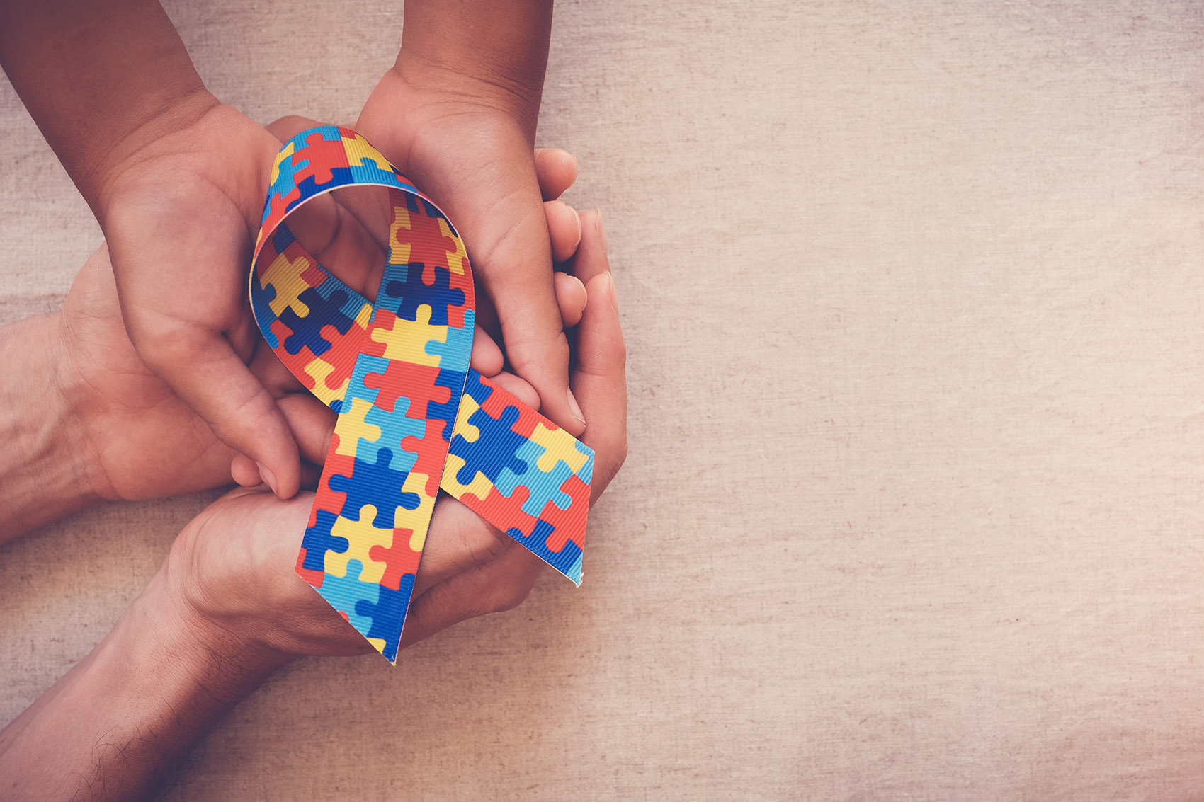 hands holdong a ribbon representing autism